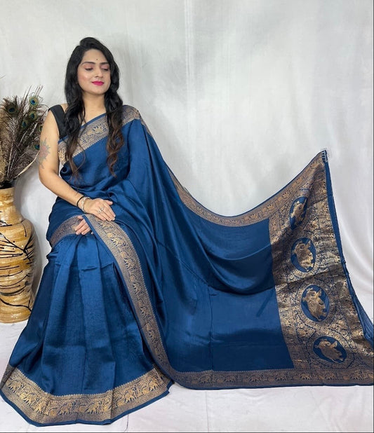Woman wearing a blue saree with gold border on a white background